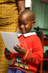 child reading paper for sponsorship